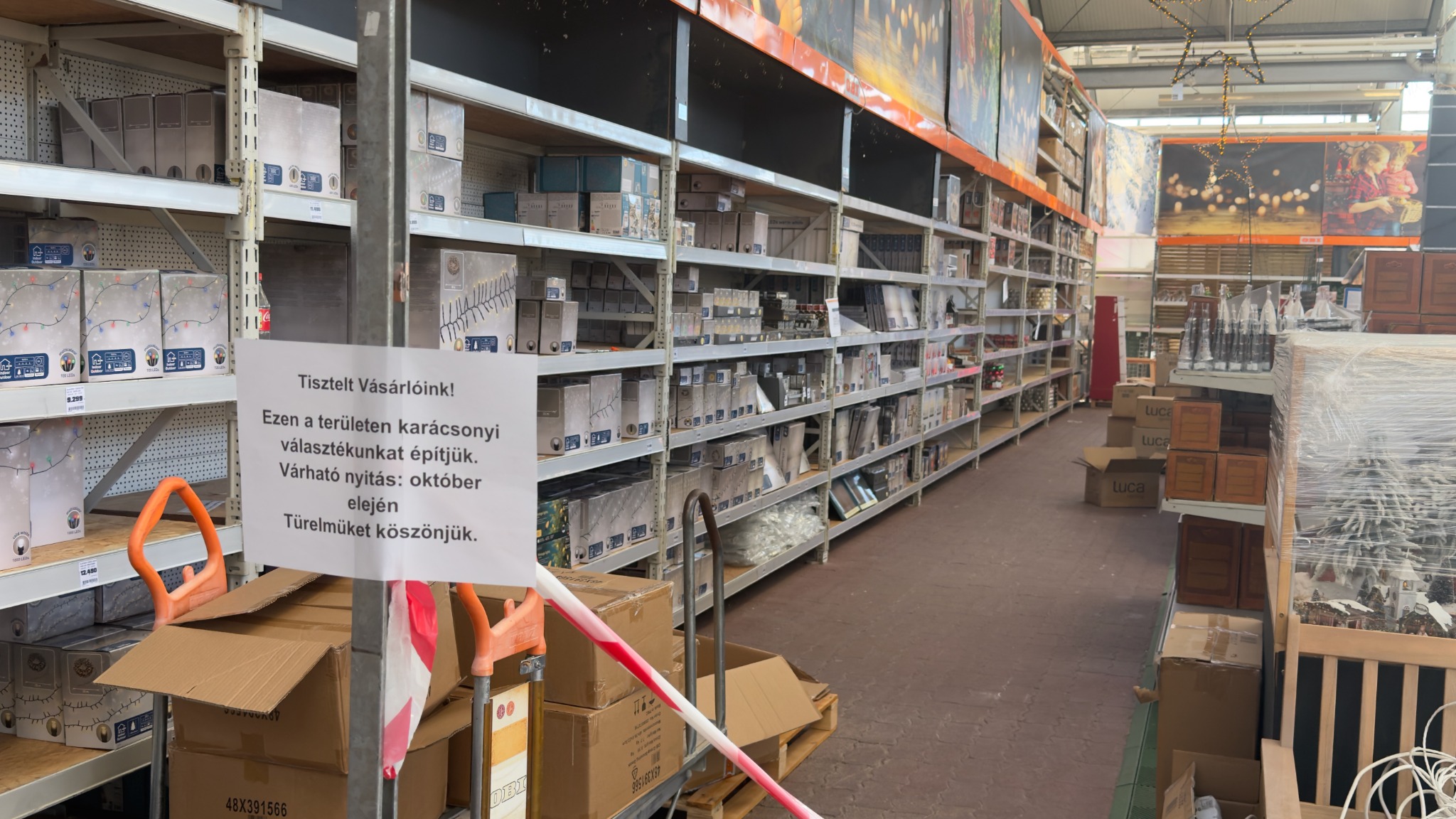Épülő karácsonyi részleg az OBI-ban, dobozokkal, lezárással és az október eleji várható nyitást jelző táblával.
