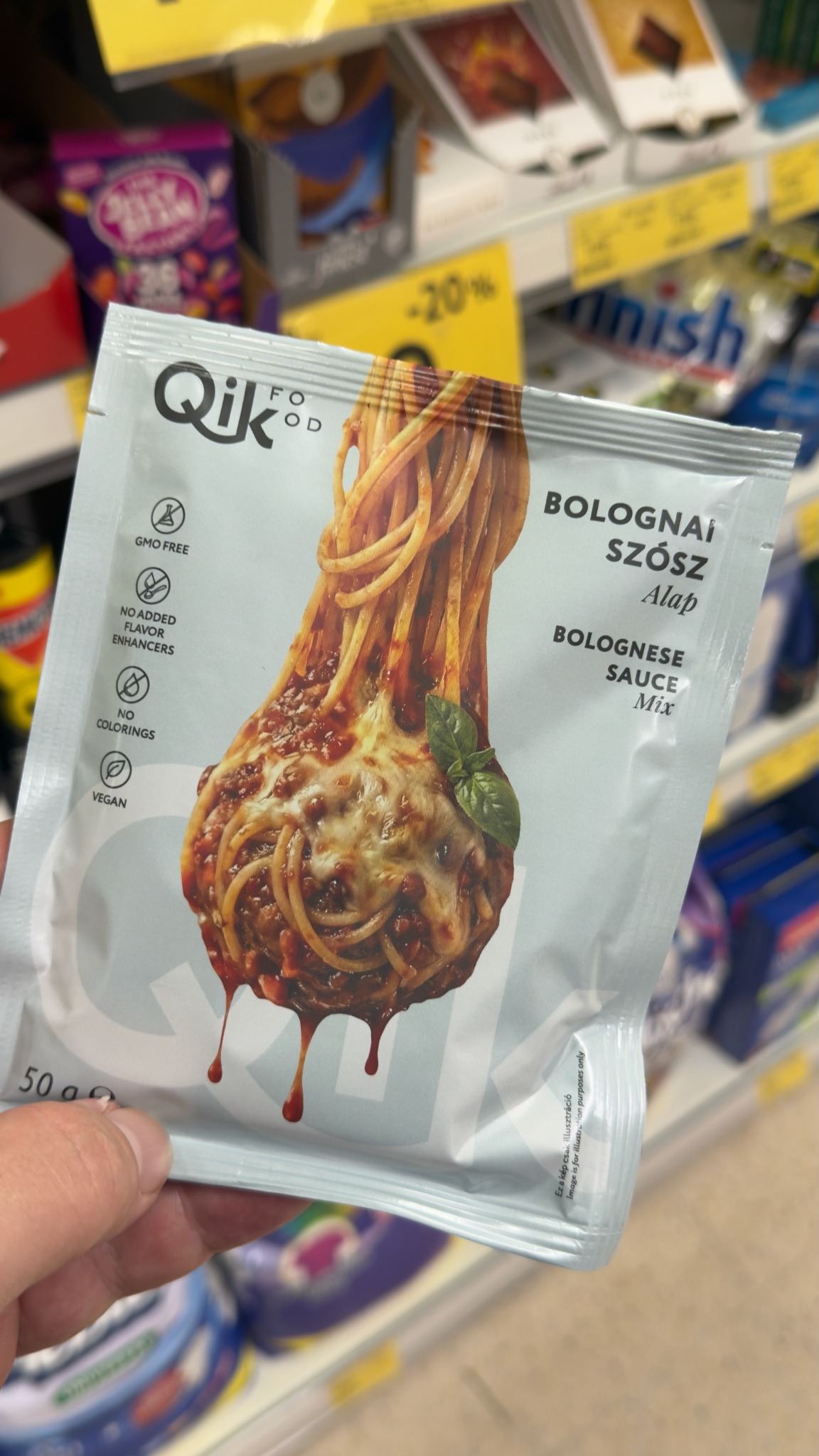 Qik Food bolognai szószalap tasakja világos háttérrel, függőlegesen megemelt, vöröses szósszal borított spagettivel és alatta szószcseppekkel.